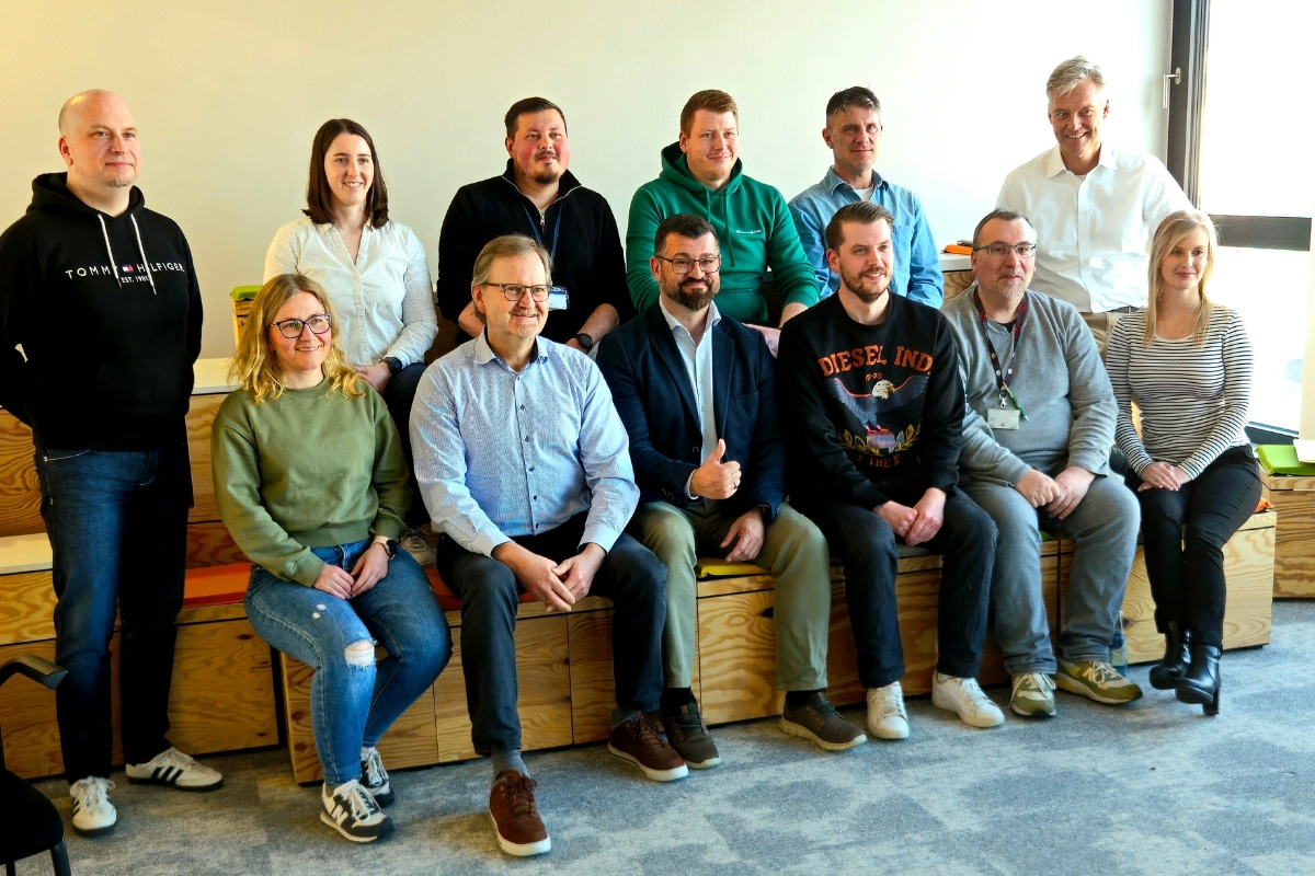 Zu sehen sind zwölf Personen, die in zwei Reihen posieren.