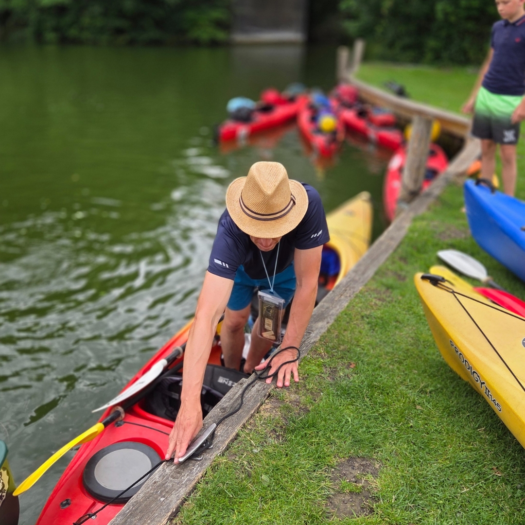 Zu sehen ist eine Person die gerade aus dem Kajak steigt