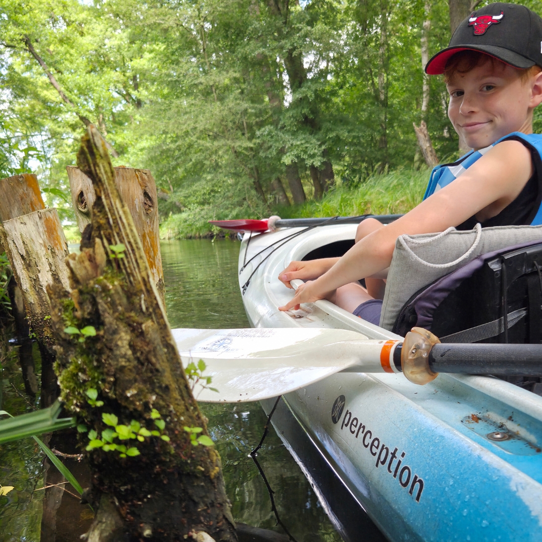 Zu sehen ist eine Person in einem Kajak auf einem See