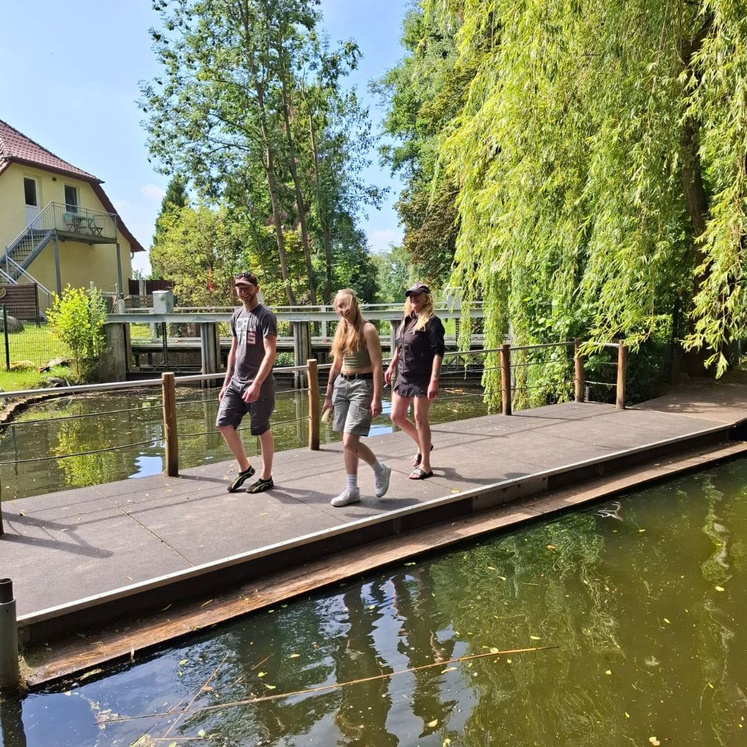 Drei Personen befinden sich auf einem Steg 