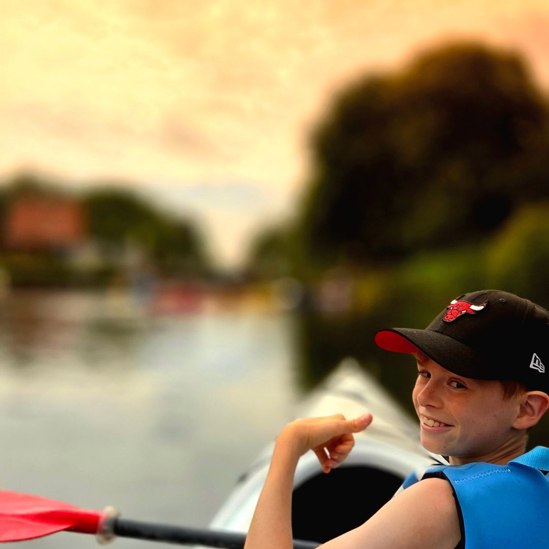 Auf dem See befindet sich eine Person in einem Kajak, während der Hintergrund unscharf erscheint